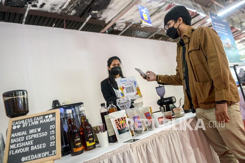 Pembeli memindai kode batang atau QR code Indonesia Standar (QRIS) di kedai kopi pada gelaran Cashless Fair by Livin