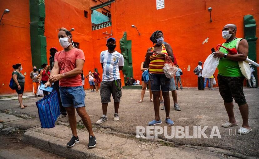 Pembeli menggunakan masker sebagai tindakan pencegahan penyebaran penyakit COVID-19 saat menunggu antrean di pintu masuk untuk berbelanja di Havana, Kuba. Kuba mengizinkan restoran, pusat perbelanjaan, dan pantai untuk dibuka kembali mulai 24 September 2021 di provinsi-provinsi yang mengalami penurunan kasus Covid-19. 