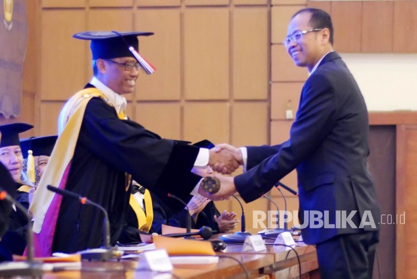 Pemberian gelar Doktor yang diserahkan Rektor Unpad Prof Dr med Tri Hanggono Acmad kepada Dirut Bank BJB Ahmad Irfan usai sidang Promosi Doktor dirinya di Aula Unpad, Jl Dipatiukur, Kota Bandung, Senin (14/8).