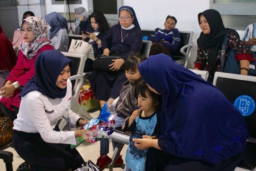 Pemberian hadiah dari petugas kepada penumpang anak di Stasiun Tugu Yogyakarta, Senin (23/7). 