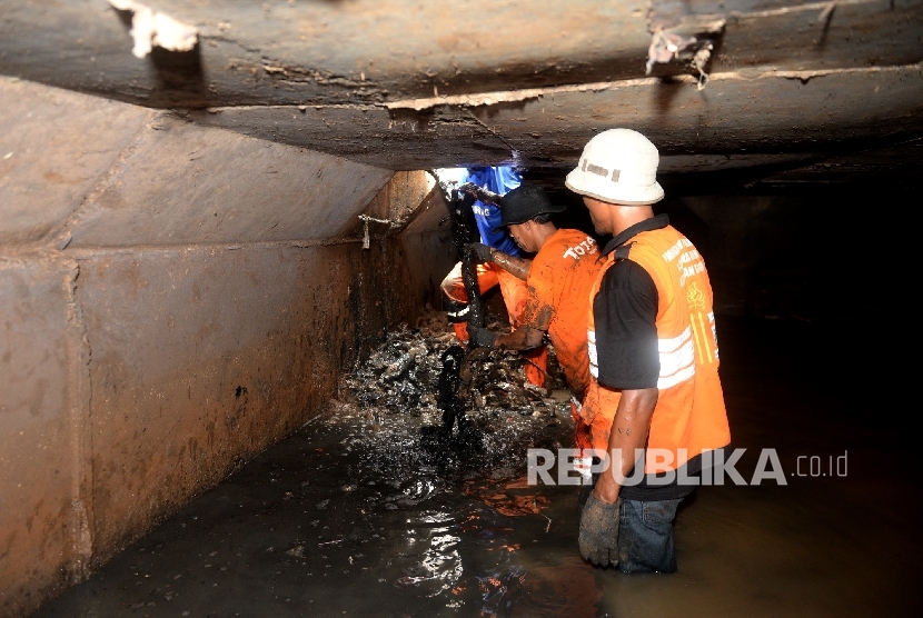 Pembersihan Saluran Air. Satuan Petugas Kebersihan Sudin Tata Air mengangkat limbah kabel dari saluran air di Jalan Merdeka Selatan, Jakarta Pusat, Rabu (2/3).