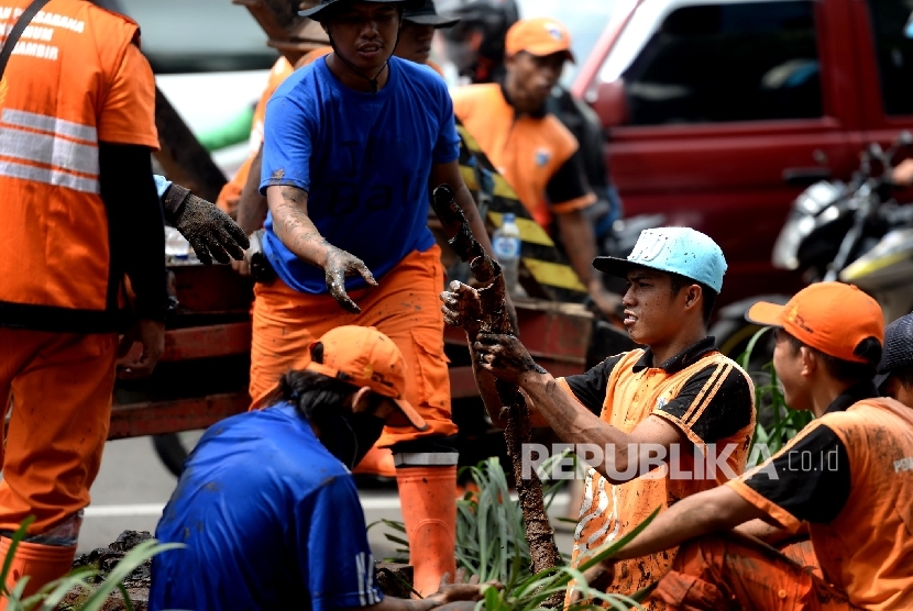 Pembersihan Saluran Air. Satuan Petugas Kebersihan Sudin Tata Air mengangkat limbah kabel dari saluran air di Jalan Merdeka Selatan, Jakarta Pusat, Rabu (2/3).