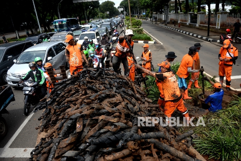 Pembersihan Saluran Air. Satuan Petugas Kebersihan Sudin Tata Air mengangkat limbah kabel dari saluran air di Jalan Merdeka Selatan, Jakarta Pusat, Rabu (2/3).