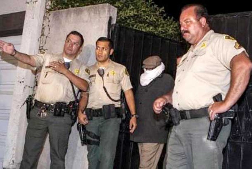 Pembuat film anti-Islam, Nakoula Basseley, menggunakan selendang putih untuk menutup muka digelandang oleh polisi Los Angeles. Kejaksaan wilayah LA menyatakan, Nakoula, resmi ditahan Kamis (27/9/2012)