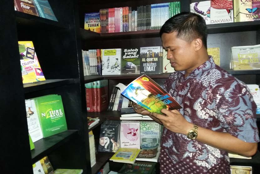 Pemenang kedua Bilik Sastra Award 2015 Agus Purwanto tengah menyimak novel Bidadari-Bidadari Surga karya Tere Liye di Toko Buku Republika, Jakarta, Senin (2/11).