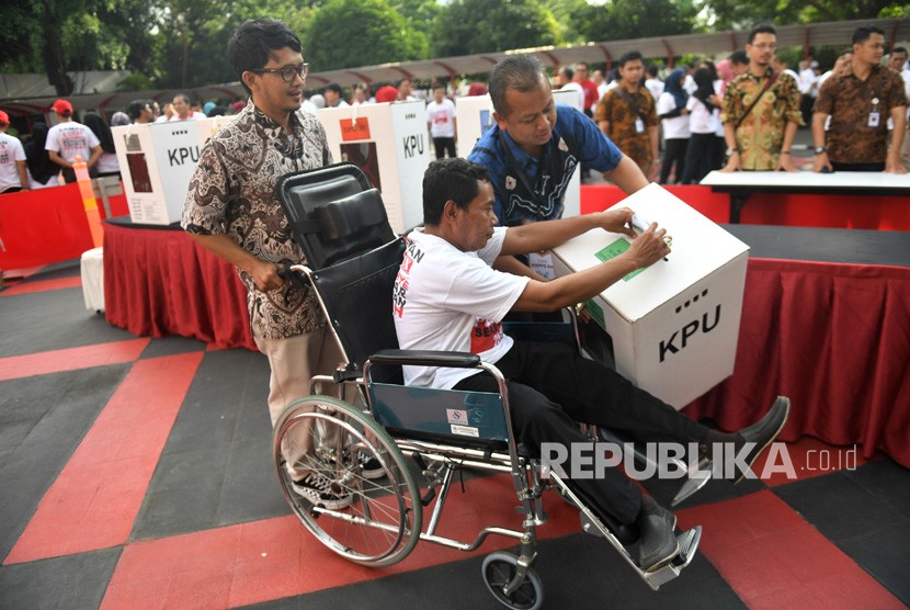 Pemeran penyandang disabilitas memasukkan surat suara dalam simulasi Pemilu 2019 di Kemendagri, Jakarta, Jumat (22/3/2019).