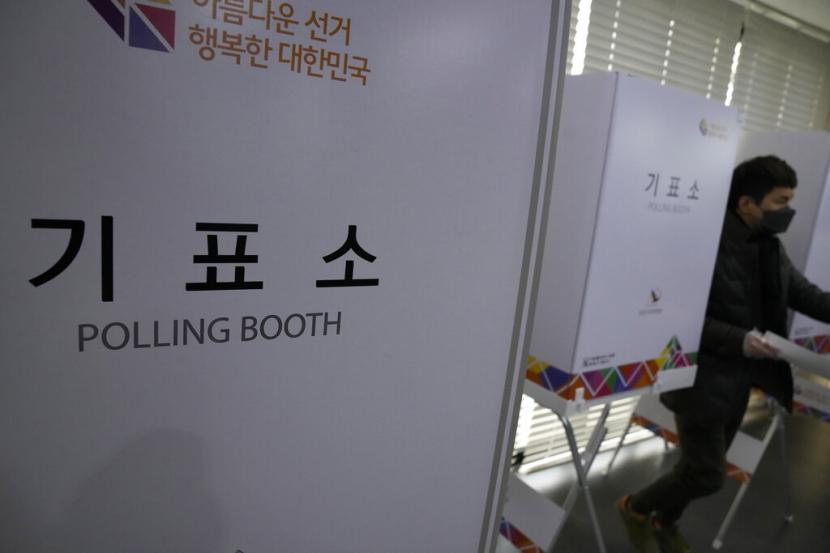 Pemilih keluar dari bilik pemilihan di Seoul, Rabu (9/3/2022).