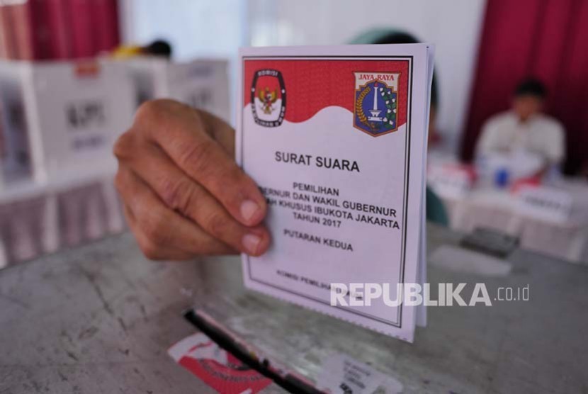 Pemilih memasukkan surat suara di sebuah TPS di Jatipadang pada Pilkada DKI Putaran 2, Rabu (19/2).