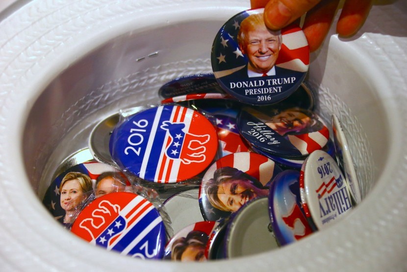 Pemilih mengambil bros bergambar kandidat Donald Trump. Hari ini (9/11) dunia akan mengetahui hasil Pilpres AS.
