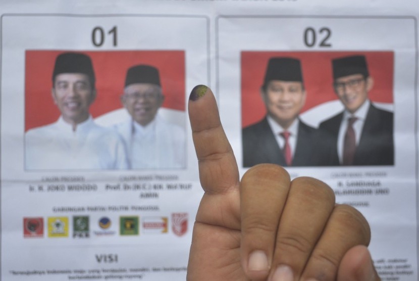 Pemilih menunjukkan jari kelingking usai menggunakan hak pilihnya.