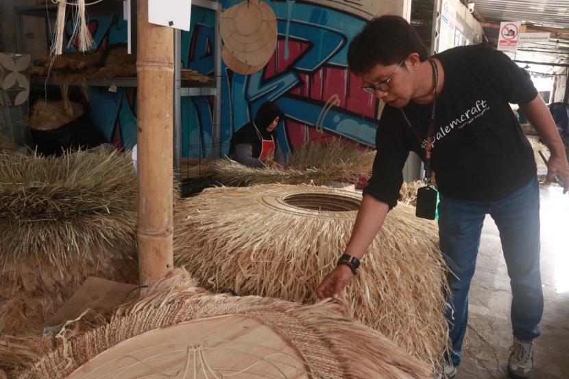 Pemilik Palem Craft, Deddy, saat melihat proses pembuatan produknya di salah satu Gudang Palem Craft.