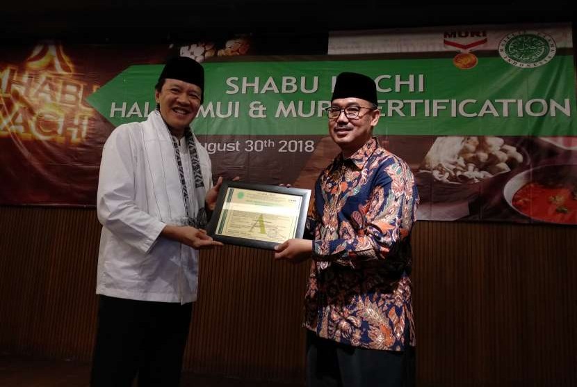 Pemilik Restoran Shabu Hachi (kiri) menerima sertifikat halal MUI yang diserahkan oleh Direktur LPPOM-MUI Lukmanul Hakim (batik) di Resto Shabu Hachi cabang Bogor, Kamis (30/8). Selain menerima sertifikat halal, Shabu Hachi juga meraih rekor MURI.