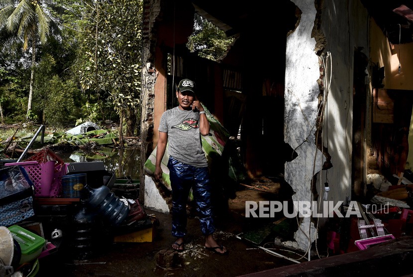 Pemilik rumah singgah berada didepan bangunan miliknya yang hancur akibat terjangan gelombang tsunami Selat Sunda di Anyer Carita, Banten, Rabu (26/12/2018).