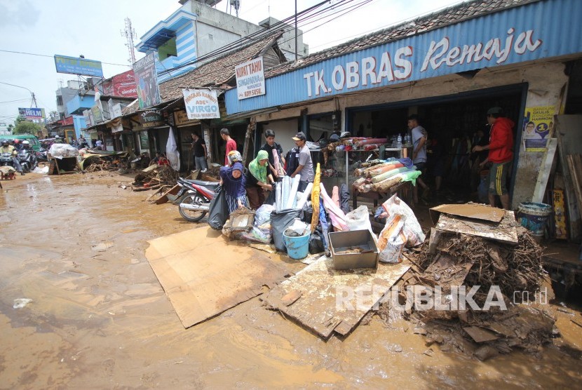 Pemilik toko dan kios membersihkan lumpur sisa banjir bandang di kawasan Cicaheum, Kota Bandung, Rabu (21/3).