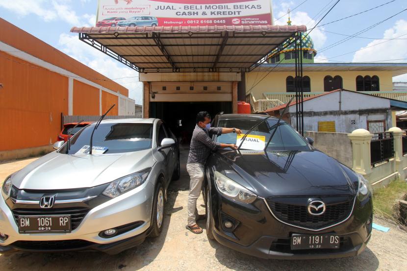 Pemilik toko meletakkan papan tanda dijual sebuah mobil bekas pakai di Dumai, Riau, Senin (22/3). Badan Pusat Statistik (BPS) menyebut, insentif pembebasan Pajak Penjualan atas Barang Mewah (PPnBM) untuk mobil berkapasitas mesin hingga 1.500 cc secara nyata memberikan dampak pada penurunan harga mobil di puluhan kota.