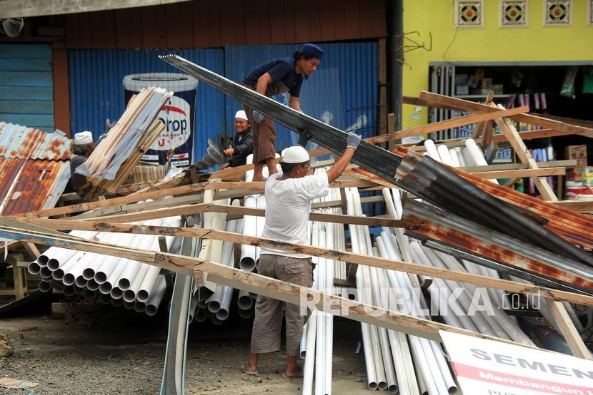 Pemilik toko membereskan barang-barang yang masih bisa diselamatkan pascagempa bumi di Mamuju, Sulawesi Barat, Selasa (19/1/2021). Memasuki hari kelima pascagempa bumi Mamuju-Majene berkekuatan Magnitudo 6,2, warga yang memgungsi mulai kembali ke rumahnya, membuka toko dan mencari sisa barang yang tersisa. ANTARA FOTO .