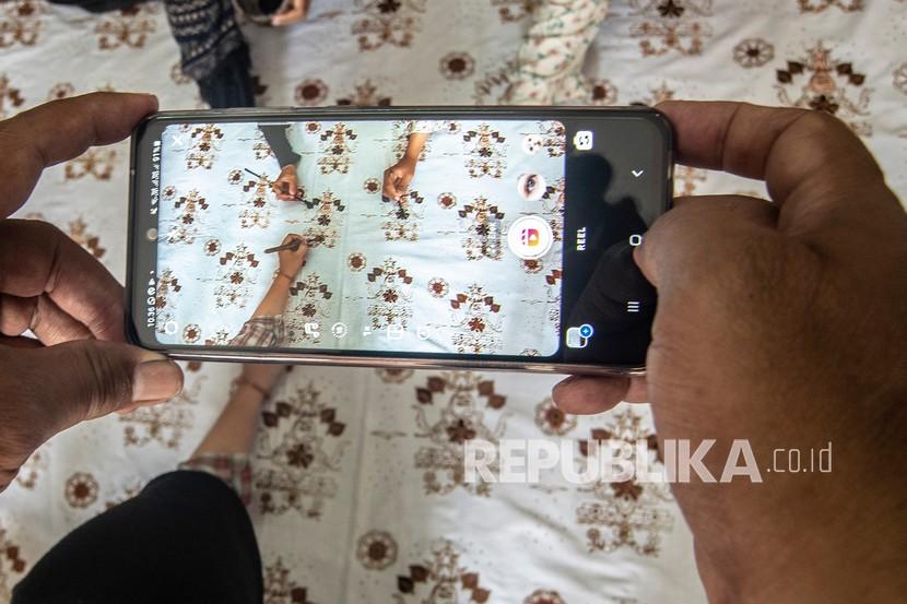 Pemilk sentra kerajinan batik memotret produk Batik Ajbura Tradjumas miliknya di Depok, Jawa Barat,. Pelaku UMKM kini semakin banyak yang terhubung ke dalam ekosistem digital. (ilustrasi)