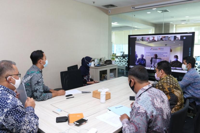 Pemimpin Divisi Komersial BNI Syariah, Daryanto Tri Sumardono (dua dari kiri) dan Direktur Utama PT Pertamina Trans Kontinental, Nepos MT Pakpahan (di layar, tengah) saat acara penandatangan akad pembiayaan investasi musyarakah dengan PT Pertamina Trans Kontinental senilai Rp175 miliar secara virtual pada Kamis (1/10). 