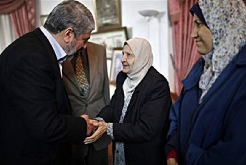 Pemimpin Hamas, Khaled Mashaal bersalaman dengan hadija, saudara perempuan Yasser Arafat di Gaza City, 9 Desember, 2012