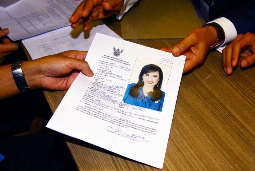Pemimpin partai Thai Raksa Chart, Preecha Pholphongpanich (kanan) menyerahkan surat dengan foto Putri Ubolratana kepada petugas KPU di Bangkok, Thailand, Jumat (8/2).