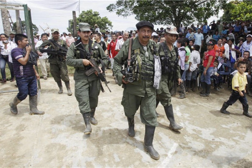 Pemimpin pemberontak FARC, Jairo (tengah), berjalan di San Isidro, Kolombia. 