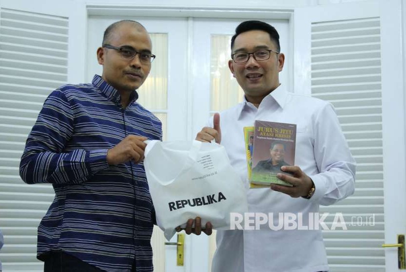 Pemimpin Redaksi Irfan Junaidi (kiri) memberikan buku kepada Gubernur Jawa Barat Ridwan Kamil (Emil) saat bersilaturahim dengan Gubernur Jawa Barat, di Gedung Pakuan, Kota Bandung, Rabu (12/9).