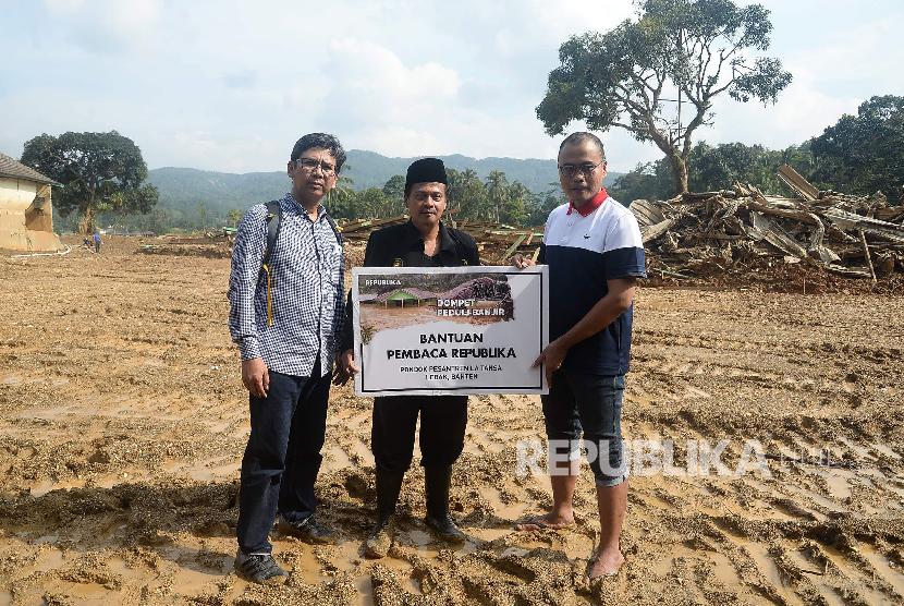 Pemimpin Redaksi Republika Irfan Junaidi (kanan) didampingi Direktur Oprasional Republika Arys Hilman (kiri) menyerahkan bantuan pembaca republika kepada pimpinan Pondok Pesantren La Tansa KH Adrian Mafatihullah Karim (tengah) di Komplek Pondok Pesantren La Tansa, Lebak, Banten, Rabu (15/1). 