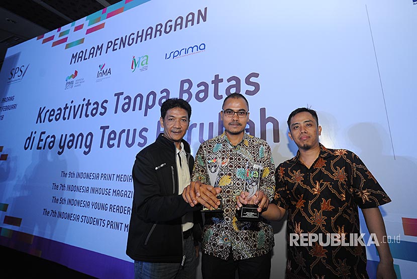 Pemimpin Redaksi Republika Irfan Junaidi (tengah) diapit Kepala Bagian Desain Sarjono (kiri) dan Kepala Bagian Infografis Ali Imron berfoto dengan Piala Indonesia Print Media Awards (IPMA) dan Indonesia Young Reader Awards (IYRA)2018.