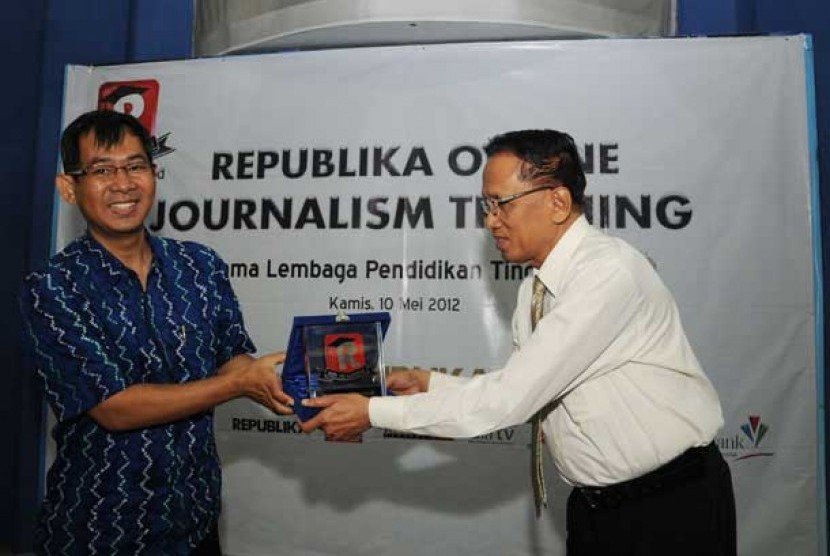 Pemimpin Redaksi Republika, Nasihin Masha (kiri) menyerahkan plakat kepada Direktur P3M Universitas Persada Indonesia Y.A.I, Prof Anoesyirwan Moeins (kanan) saat membuka acara Republika Online Journalism Training di Kampus YAI, Jakarta,Kamis (10/5).