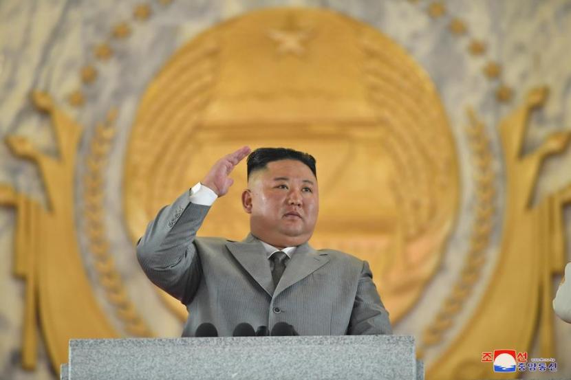 Pemimpin tertinggi Korea Utara, Kim Jong Un memberikan hormat kepada parade militer dalam perayaan 75 tahun Partai Buruh, di Pyongyang, Sabtu (10/10).