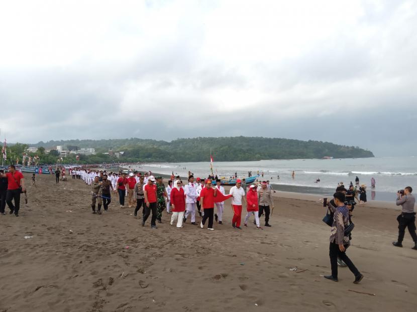 Pemkab Pangandaran melakukan pengibaran bendera merah putih sepanjang 1 kilometer di Pantai Pangandaran, Kamis (18/8/2022). 
