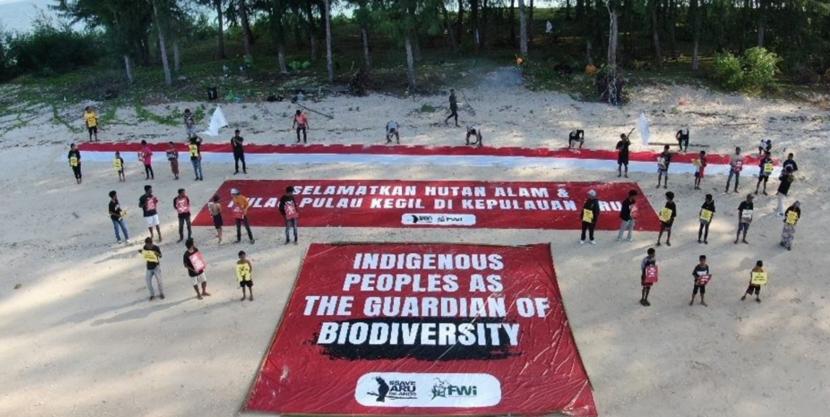 Pemuda adat membentangkan spand raksasa untuk selamatkan Hutan Aru di  Pantai Pulau Kumareri, Kabupaten Kepulauan Aru, Maluku.