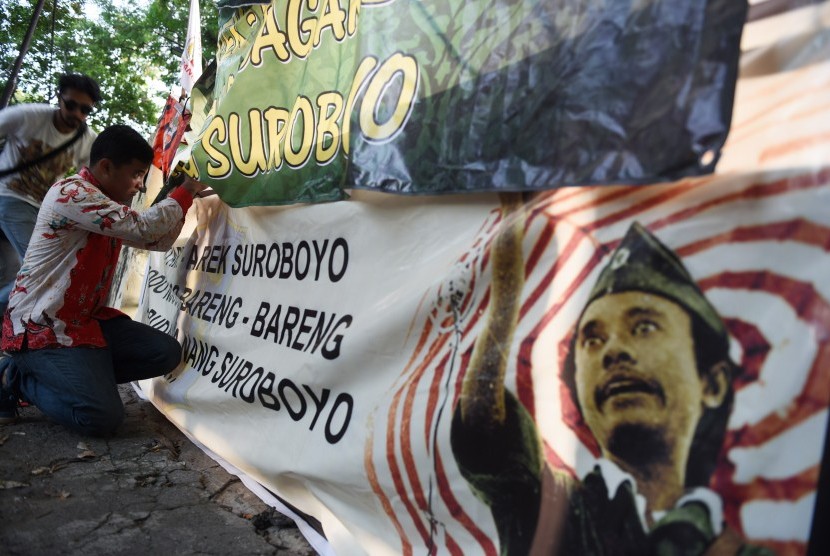 Pemuda dari berbagai organisai pemuda dan mahasiswa membentangkan spanduk di lokasi bekas Kantor Radio Pejuang Surabaya, Bung Tomo yang telah dibongkar di Surabaya, Jawa Timur, Jumat (13/5). 