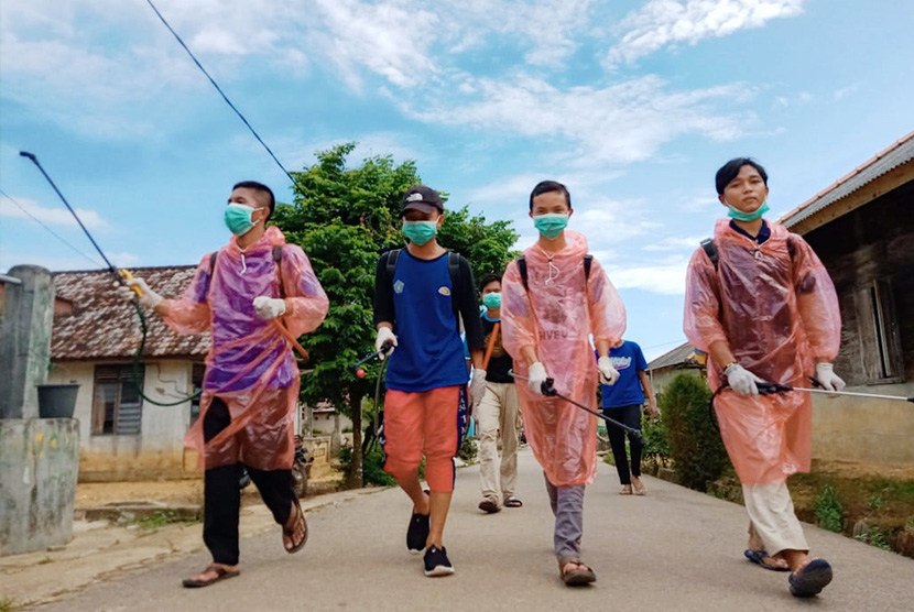 Pemuda dari Yayasan Arah Pemuda Indonesia dan Karang Taruna Desa Kemuja Bangka melakukan penyemprotan disinfektan di ruang publik Desa Kemuja. 