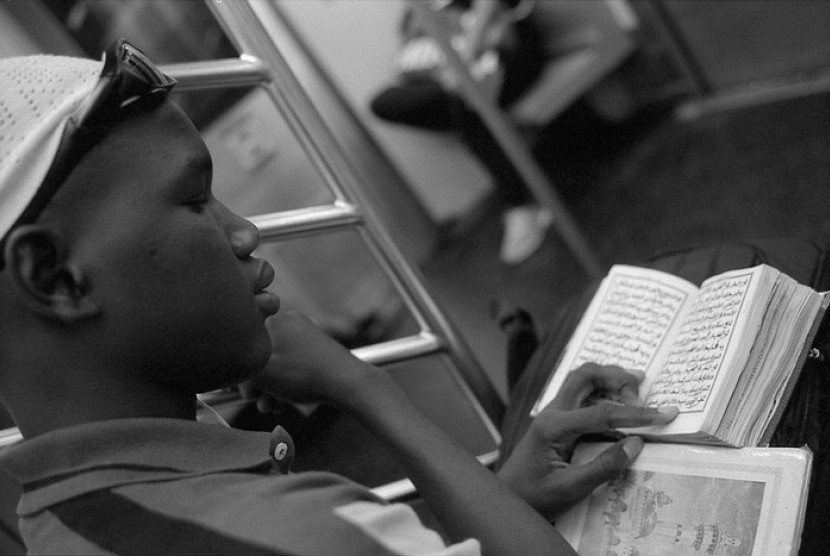 Pemuda Muslim keturunan Afrika sedang membaca Alquran di kereta Uptown 6 di Manhattan, New York.