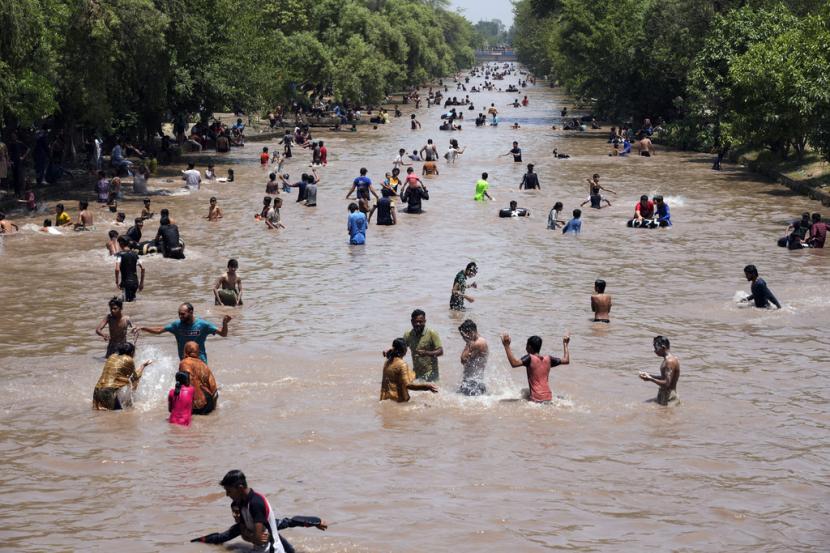 Pemuda Pakistan menyejukkan diri di kanal saat cuaca panas di Lahore, Pakistan, Ahad, 26 Mei 2024.