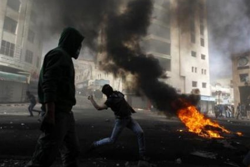 Pemuda Palestina melempar batu ke pasukan Israel dalam konfrontasi di Tepi Barat