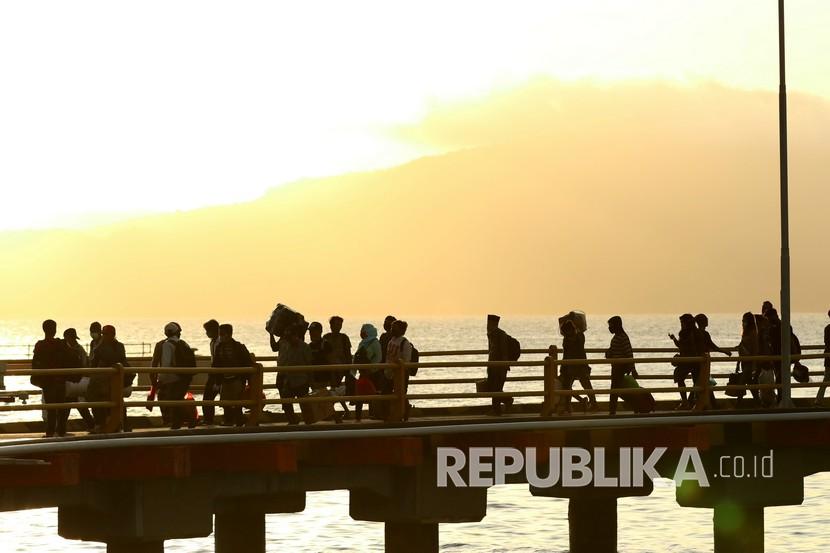 Pemudik berjalan usai turun dari kapal di Pelabuhan Ketapang, Banyuwangi, Jawa Timur, Senin (18/5/2020). Jika warga tetap nekat mudik, kasus Covid-19 diprediksi melonjak pada Juni. Ilustrasi