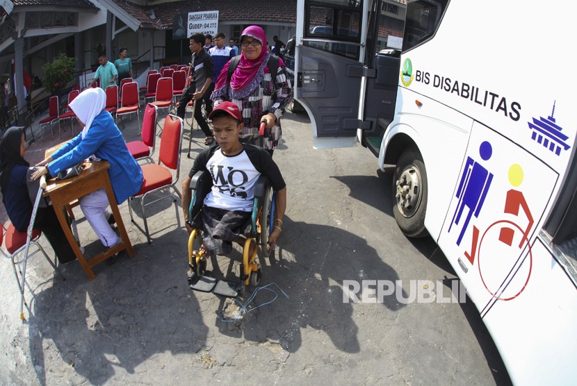 Pemudik difabel dibantu relawan bersiap menaiki bus khusus penyandang disabilitas (foto ilustrasi). Kemenhub menggelar mudik gratis untuk difabel pada Natal 2019.