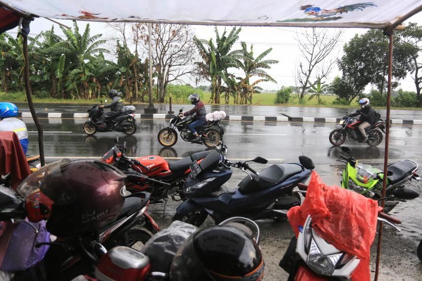 Warga menerobos hujan saat melintas di jalur Pantura, Widasari, Indramayu. Badan Meteorologi Klimatologi dan Geofisika (BMKG) mengimbau pemudik untuk tetap waspada terhadap perubahan cuaca, potensi hujan lebat dan angin kencang wilayah Pantai Utara Jawa.