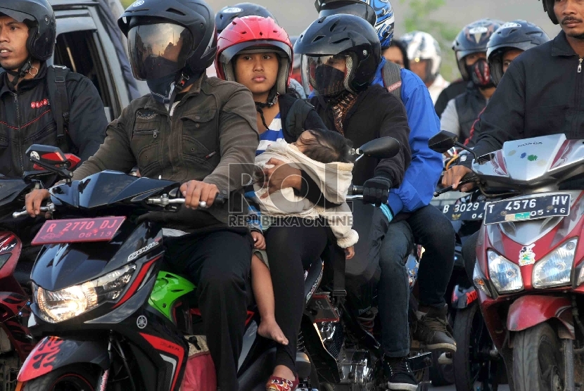  Pemudik motor membawa anak mereka yang masih kecil saat melintas di kawasan Karawang, Jawa Barat. ilustrasi