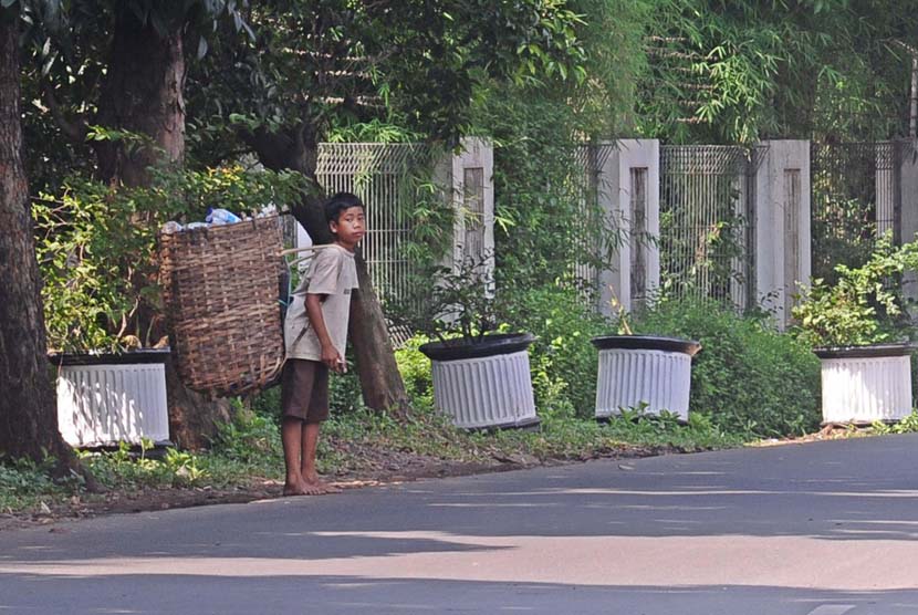 Pemulung cilik berjalan saat mencari sisa sampah di daerah Pondok Gede, Jakarta Timur, Jumat (16/5).