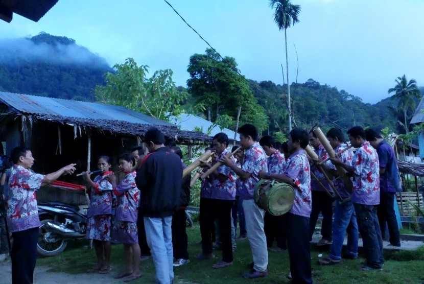 Pemusik bambu Desa Mapahi menyanyikan lagu Naik Gunung dengan latar belakang kabut menyelimuti lereng Gunung Ntoriate.