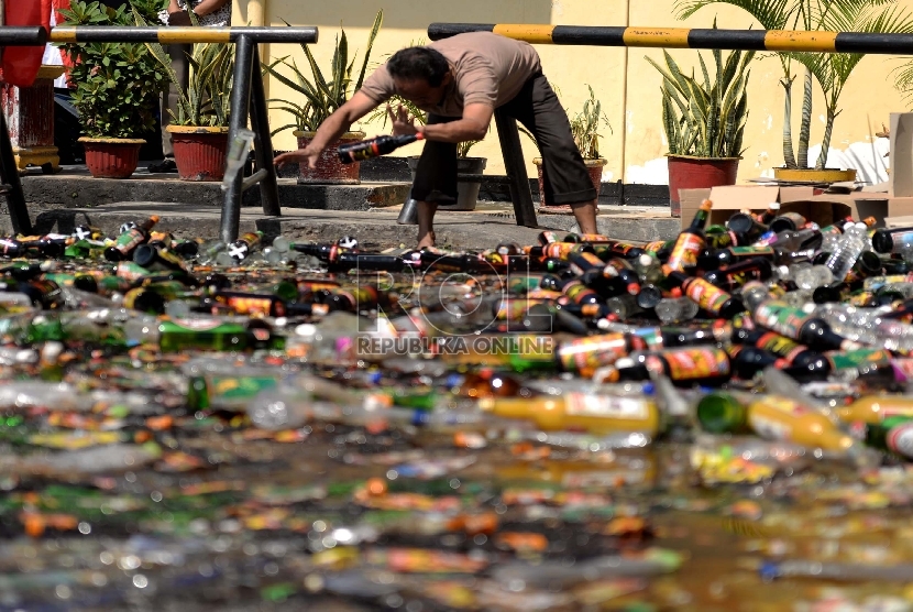 Pemusnahan Miras. Alat berat mengancurkan ribuan botol minuman keras di halaman Polres Metropolitan Jakarta Barat, Jumat (3/7).  (Republika Wihdan)