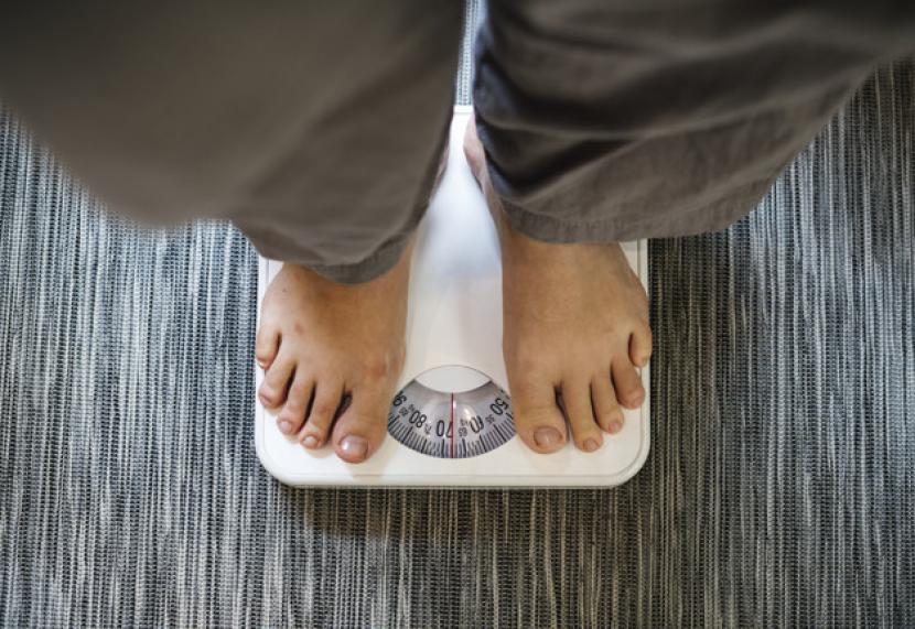 Pria obesitas sedang menimbang berat badan (ilustrasi). Viral pria di Tangerang memiliki berat 300 kg. Menurut dokter, berat badan tersebut bisa turun namun ada beberapa hal yang perlu dilakukan.