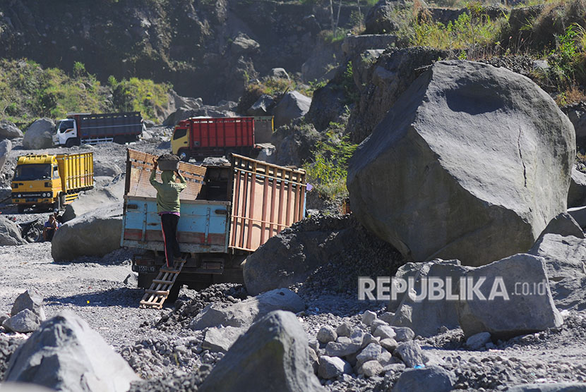 Penambang menaikkan pasir ke dalam bak truk di aliran Kali Woro lereng Gunung Merapi, Kemalang, Klaten, Jawa Tengah, Rabu (23/5). 