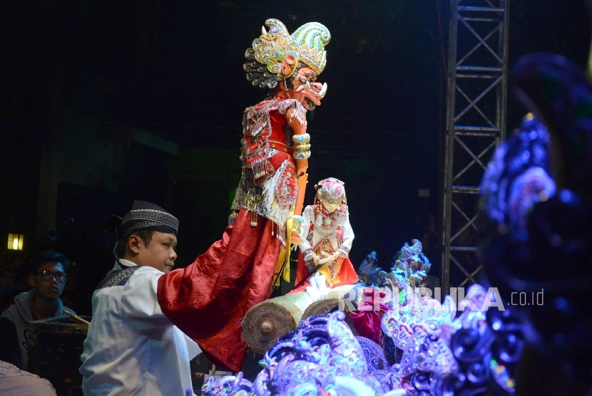 Wakil Ketua MPR RI Hidayat Nur Wahid  menyerahkan gunungan wayang kepada dalang Dadan Sunandar Sunarya dari Putra Giriharja 3 pada pagelaran wayang golek lakon Semar Tandang di Bandung, Senin (30/5) malam. (Republika/Edi Yusuf)