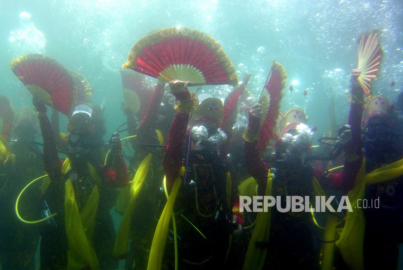 Penari memperagakan tarian Gandrung di bawah laut di Zona Konservasi Bunder, Banyuwangi, Jawa Timur, Rabu (4/4). 