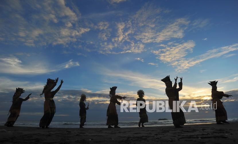 Penari menampilkan Tari Pasambahan saat matahari terbenam di Pantai Kata, Pariaman, Sumatera Barat