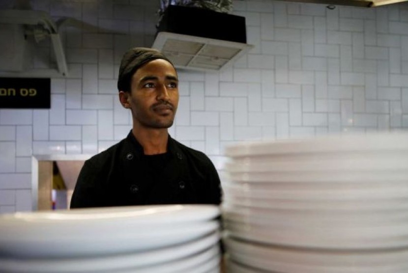 Pencari suaka asal Eritrea, Teklit Michael, 29 tahun, bekerja di dapur sebuah restoran di Tel Aviv.  
